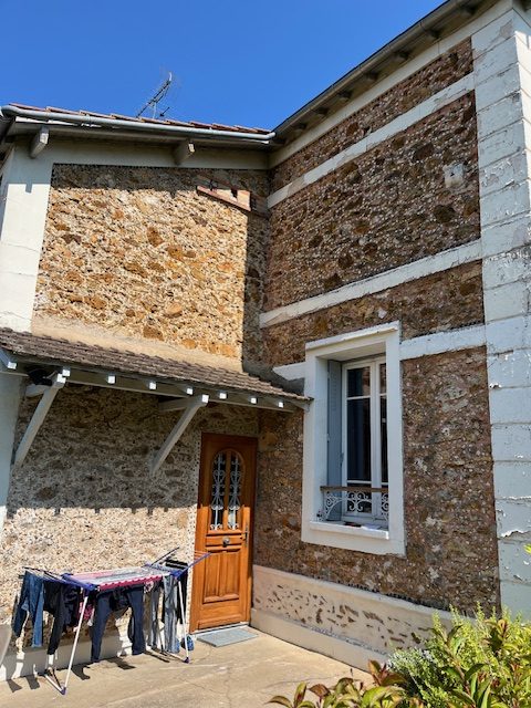 Façades du Lys : maison en pierre avec porte en bois et linge séchant.